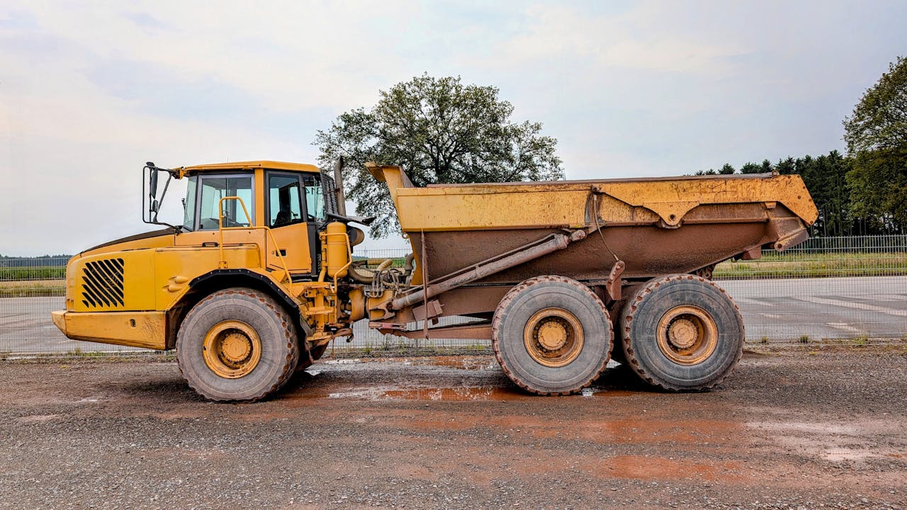 Contact A large yellow dump truck parked on a construction site in Pinneberg.